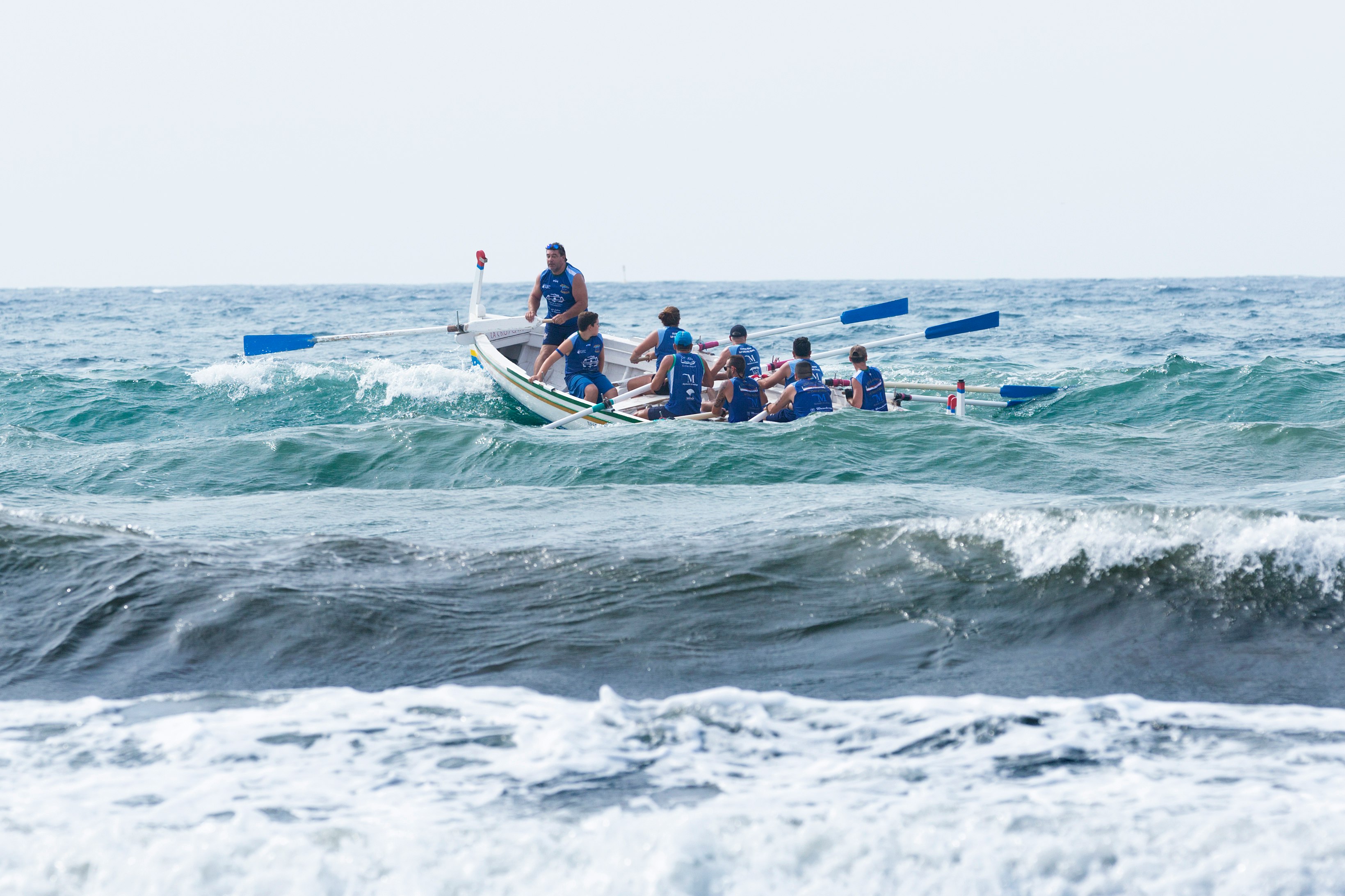 group of men boating on violent waves during daytime